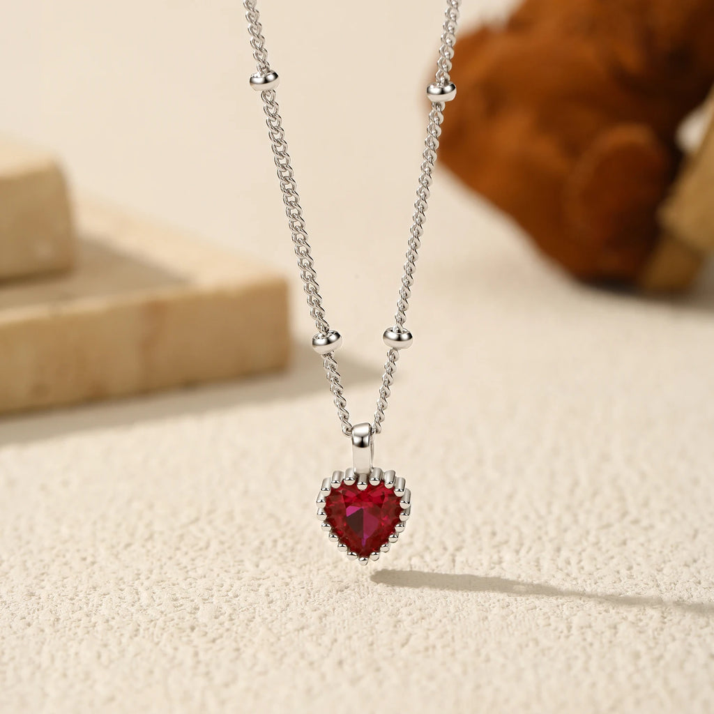 Red cubic zirconia heart pendant with a polished bail and four round chain spacer beads