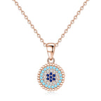 Rose gold-tone beaded evil eye necklace with light-blue, clear and dark-blue CZ stone rings on white