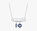Safety pin evil eye necklace in 925 sterling silver with blue Hamsa and eye charms on white