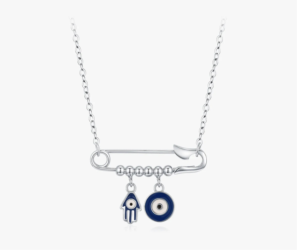 Safety pin evil eye necklace in 925 sterling silver with blue Hamsa and eye charms on white