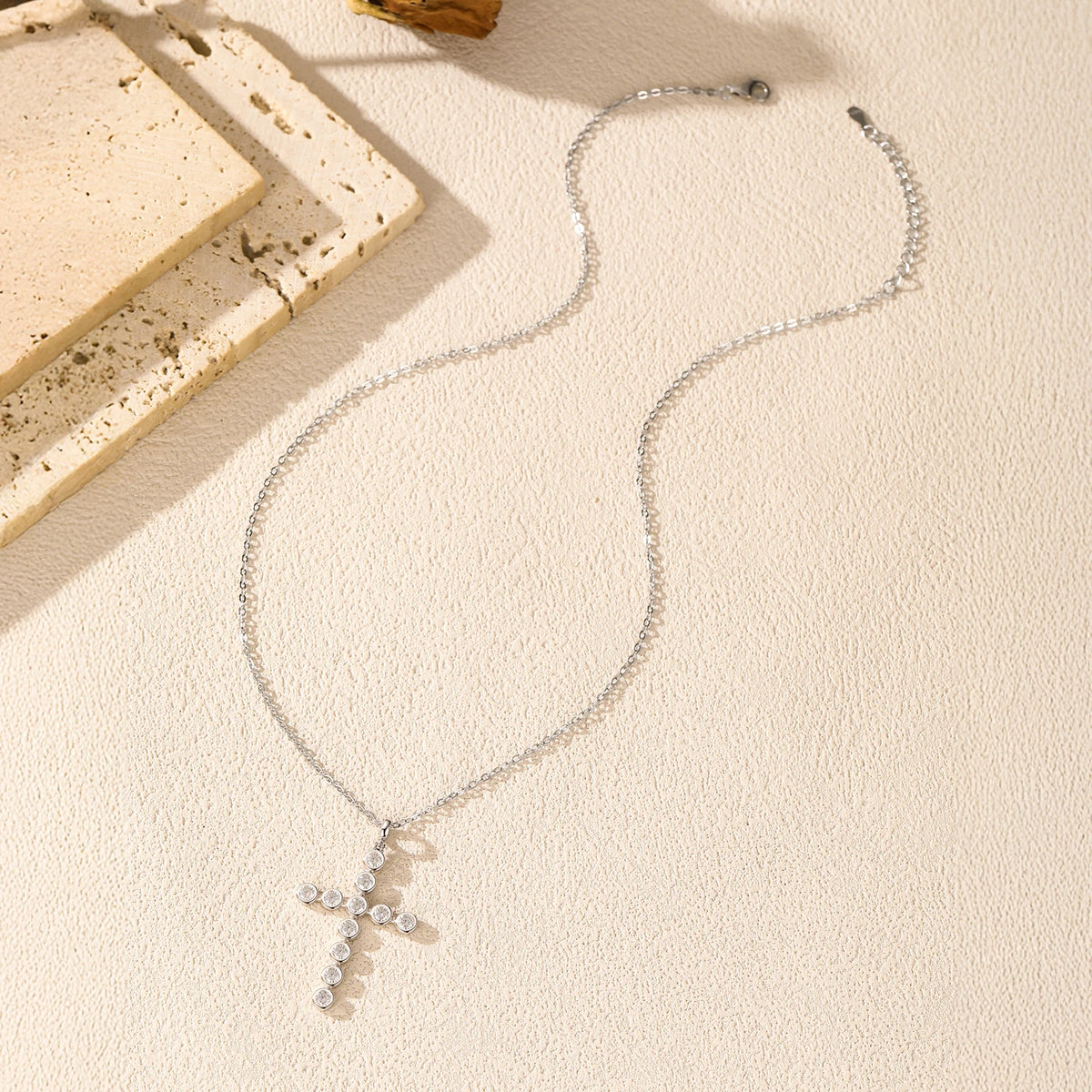 925 sterling silver moissanite cross necklace shown in a flat lay with cable chain and clasp