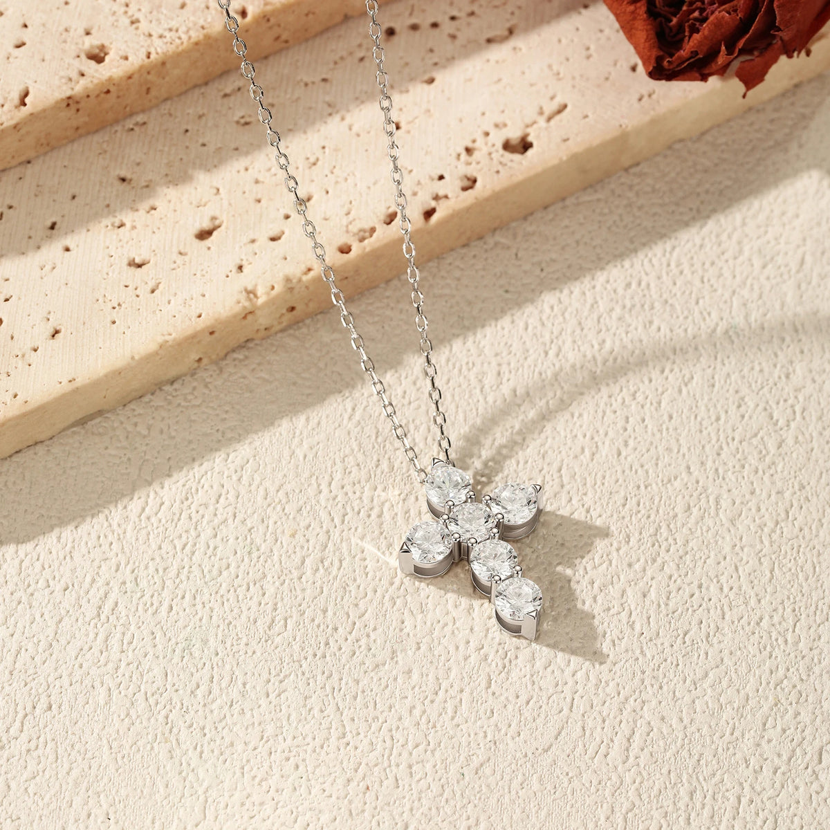 Angled view of the 925 sterling silver cross necklace showing the prong-held moissanite stone settings