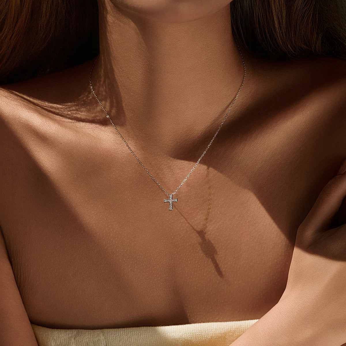 Small 925 sterling silver cross necklace with moissanite stones worn at the collarbone
