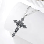 Sterling silver crucifix necklace displayed on a white curved surface with radiating rays and star circles