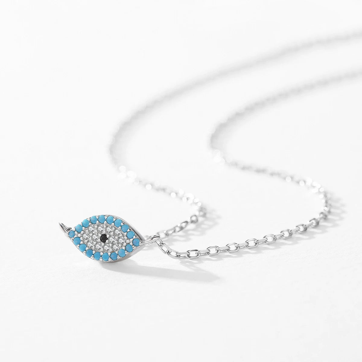 Close-up of the 925 sterling silver evil eye necklace with blue border stones and crystal-set center