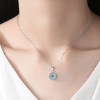 Small silver-tone beaded evil eye necklace worn at the base of the neck