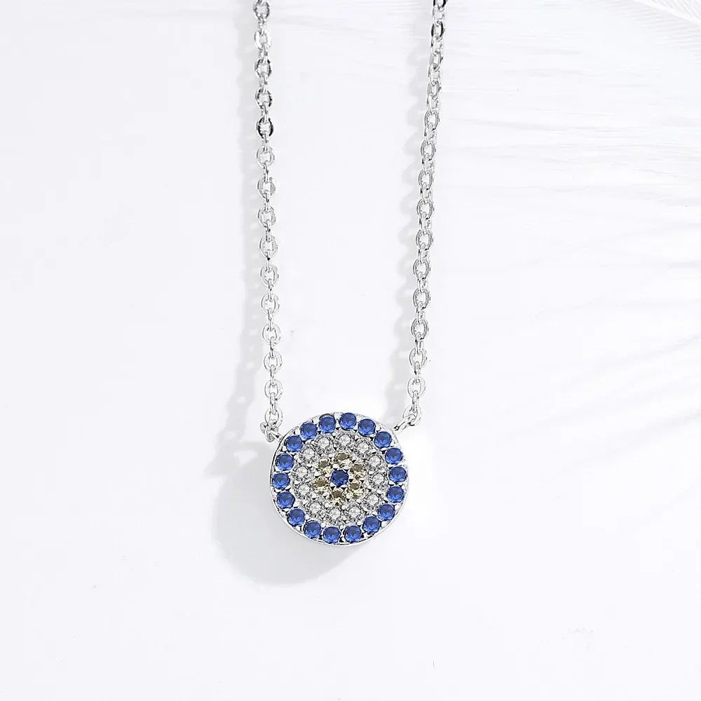 Close-up of the silver-tone round evil eye pendant with blue outer stones and yellow flower
