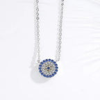 Close-up of the silver-tone round evil eye pendant with blue outer stones and yellow flower