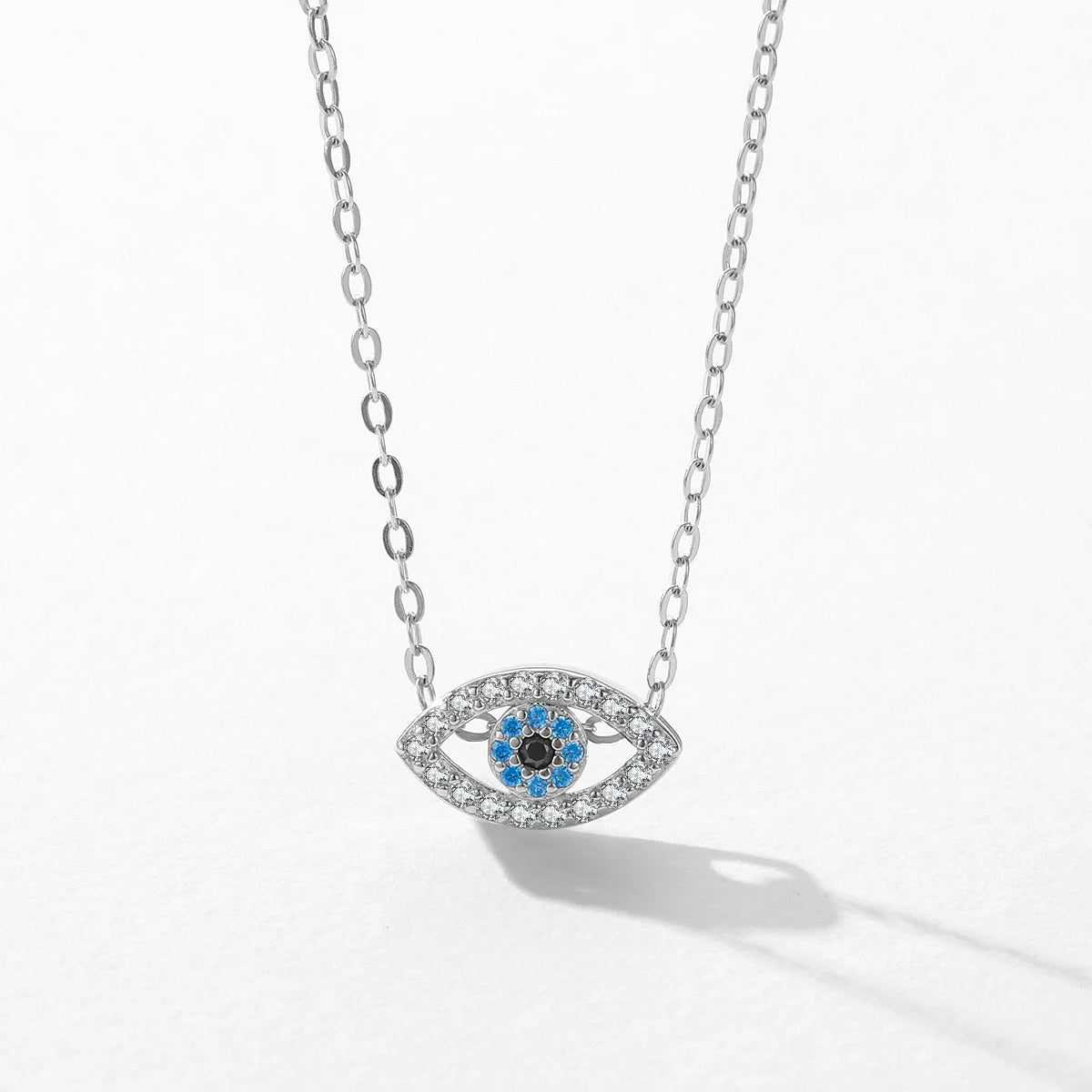 Close-up of the silver-tone open evil eye pendant with clear stones around blue and black center stones