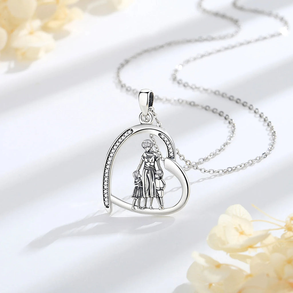 925 sterling silver family heart necklace displayed with its chain on a white surface with pale flowers