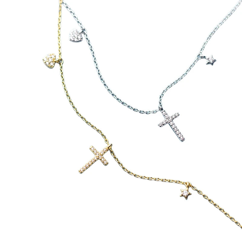 Silver-tone and gold-tone cross necklaces with stone-set hearts and polished star charms