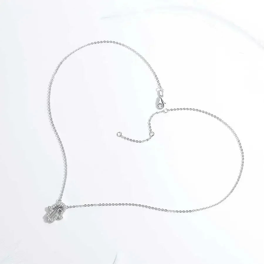 Silver-tone hamsa necklace laid open on white, showing the chain, extender, clasp, and small pendant