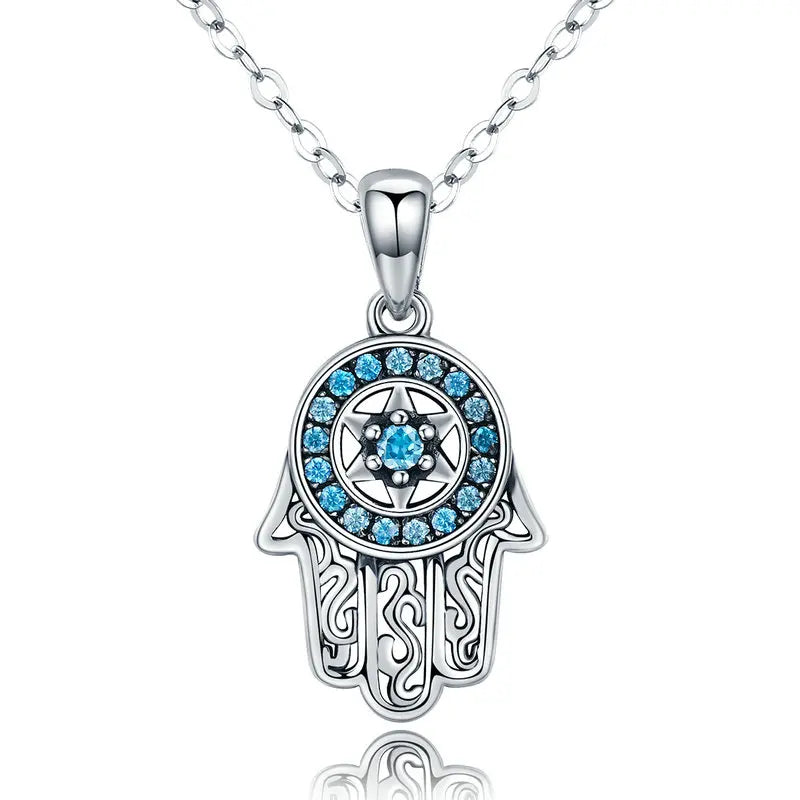 Silver-tone hamsa necklace close-up with blue CZ stones, a six-pointed star, and openwork scroll fingers