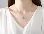 Silver-Tone hamsa hand necklace worn at the neckline with a blue evil eye center