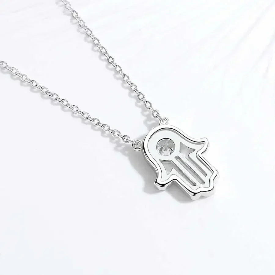 Back view of a silver-tone hamsa pendant necklace showing the open palm design and round center stone