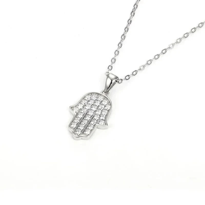 Silver-tone Hamsa pendant with clear CZ stones and an oval-link chain arranged on a white background