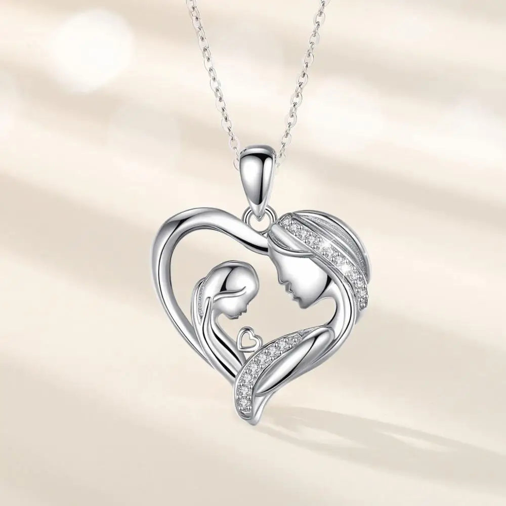Silver-tone heart pendant on an oval-link chain with facing adult and child profiles