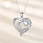 Silver-tone heart pendant on an oval-link chain with facing adult and child profiles