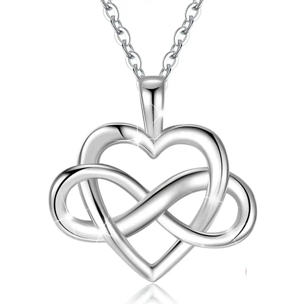 Silver open heart and woven infinity pendant suspended from a fine linked chain on white