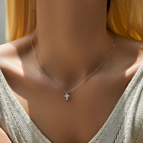925 sterling silver moissanite cross necklace worn at the collarbone with a V-neck top