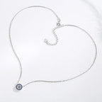 Silver-tone flower evil eye necklace laid out with a fine chain, clasp, and extender
