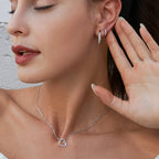 Silver-tone asymmetrical open heart necklace worn at the collarbone, with CZ stones along the lower curve