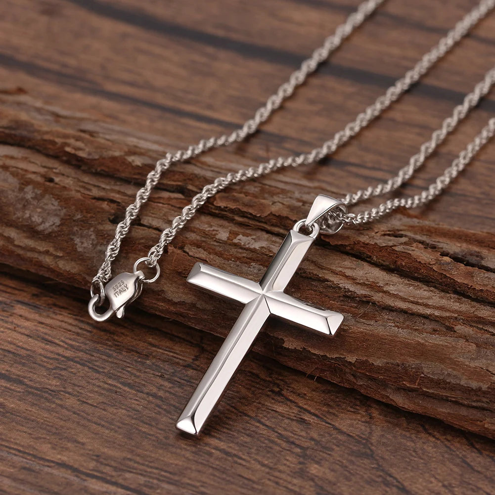 Silver-tone rope chain with a polished pointed cross pendant on wood