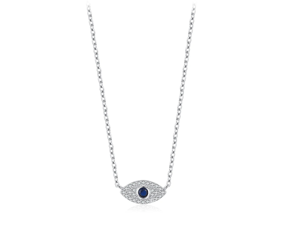Silver-tone inline evil eye necklace on white with a dark blue center and clear stones