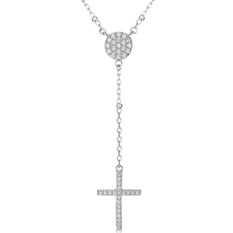 Silver-tone rosary drop necklace with round CZ center, beaded chain accents, and slim cross on white