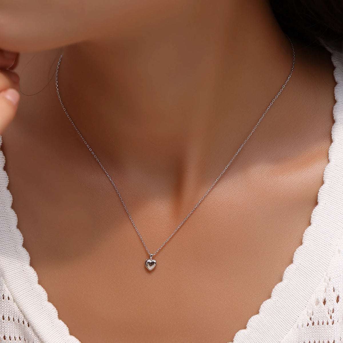 Small polished heart necklace in 925 sterling silver worn on the neck with a fine chain