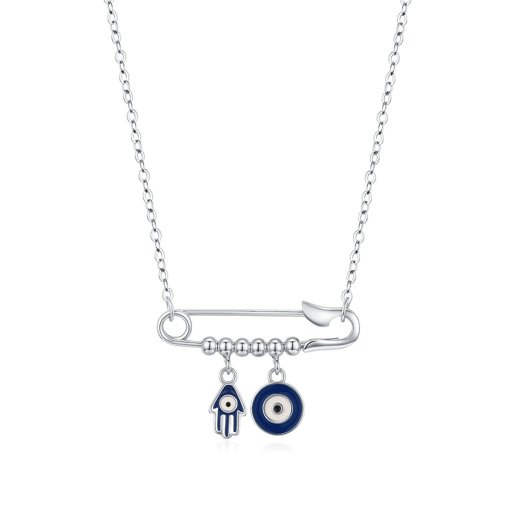 Sterling silver evil eye necklace with a horizontal safety pin, blue Hamsa charm, and round eye on white