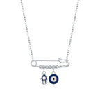 Sterling silver evil eye necklace with a horizontal safety pin, blue Hamsa charm, and round eye on white