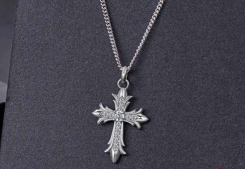 Stone-set Gothic cross pendant on a silver-tone chain against a dark textured background