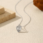 Close-up flat lay of the sterling silver heart pendant with raised beaded rim and sunburst texture