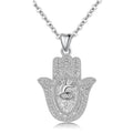 Textured 925 sterling silver hamsa hand necklace with raised eye and sunburst pendant on white