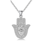 Textured 925 sterling silver hamsa hand necklace with raised eye and sunburst pendant on white