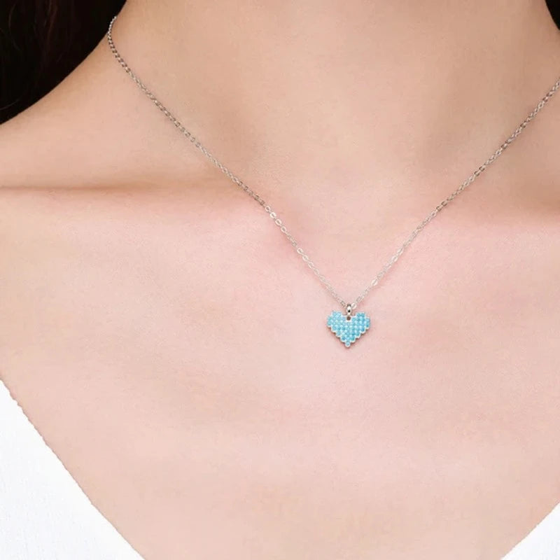 Small 925 sterling silver turquoise-colored heart necklace worn at the center of the neck