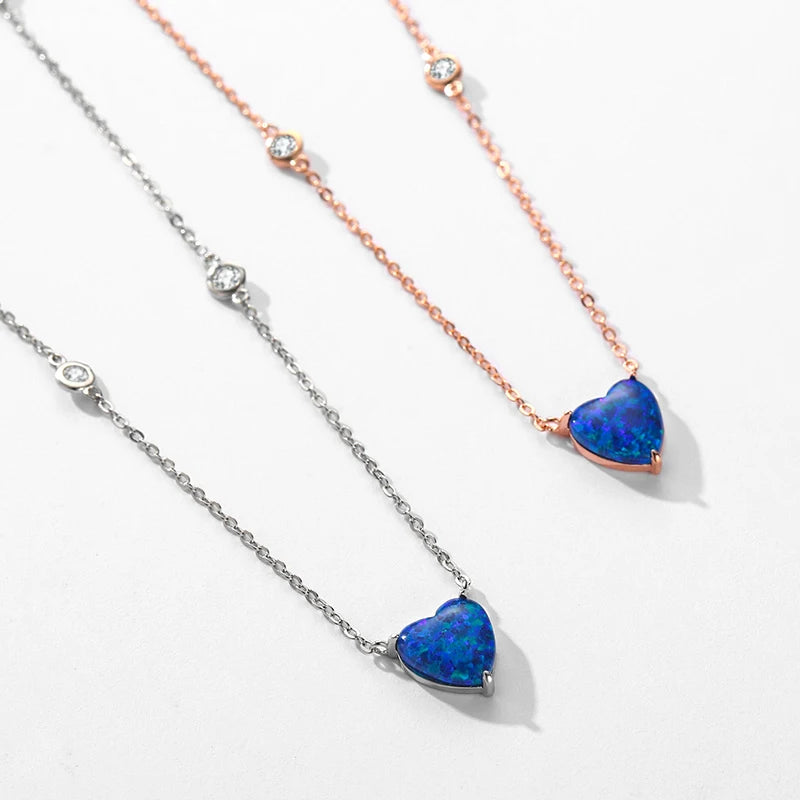 Silver-tone and rose gold-tone blue heart necklaces arranged on a white background