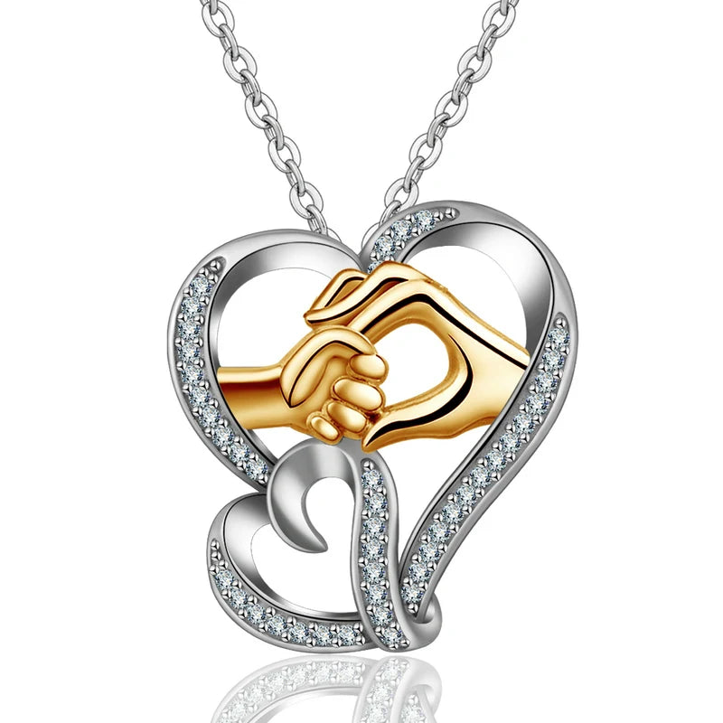 Two-tone 925 sterling silver hand in hand heart necklace with clear CZ stones on a white background