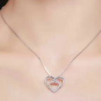 Two-tone infinity heart necklace worn just below the collarbone with a stone-set inner heart