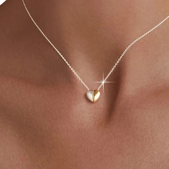 Two-tone puffed heart necklace worn at the base of the neck with a silver-tone fine chain
