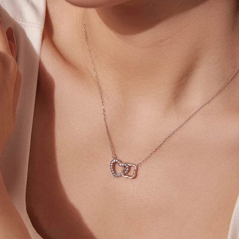 Two-tone linked heart necklace worn at the collarbone with a rose gold-plated heart