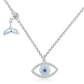 Whale tail evil eye necklace in 925 sterling silver with blue CZ stones on a white background