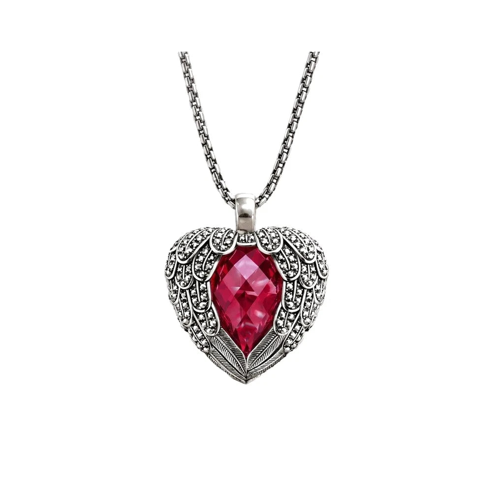 Winged heart necklace in 925 sterling silver with a faceted red CZ heart on a white background