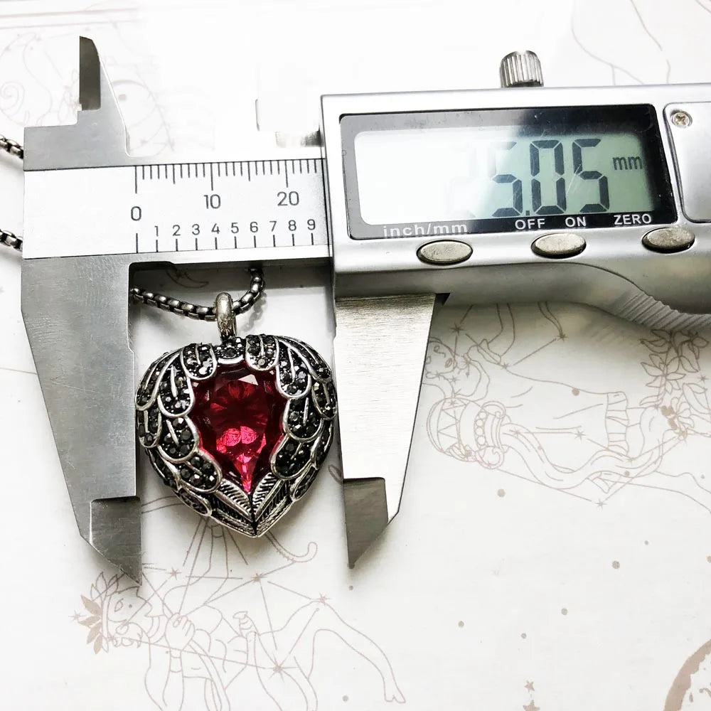 Digital caliper measuring the winged heart pendant height at 0.99 in (2.5 cm)