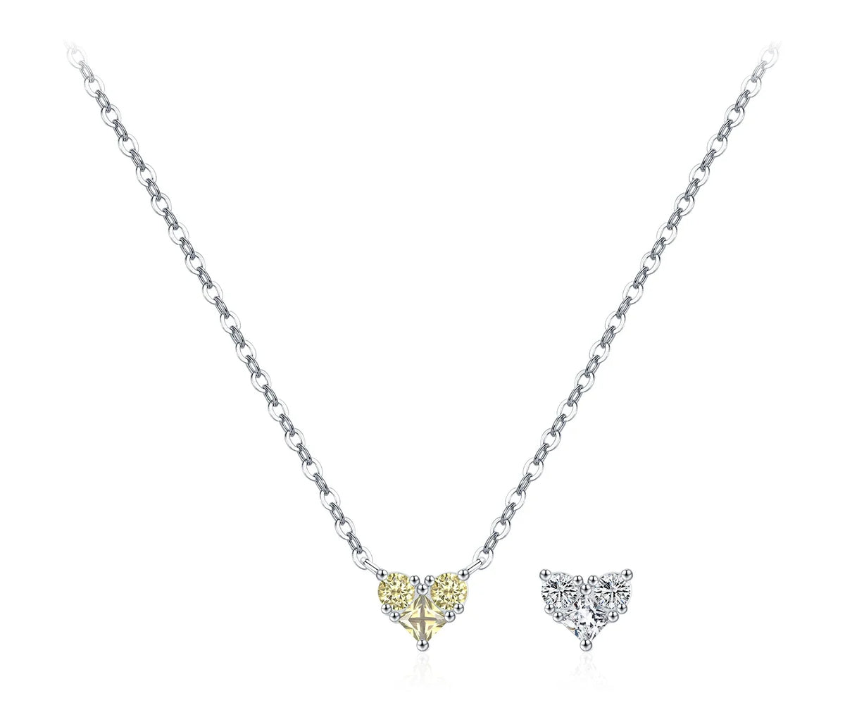 Yellow CZ heart necklace with a fine silver chain beside a clear heart motif on white